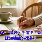 Warm natural lifestyle photo of an elderly person's hands writing in a paper notebook with a pencil at a wooden dining table, an open book and a cup of tea beside it, soft morning sunlight through a window, beige and warm wood tones, muted sage green accent, shallow depth of field, gentle and hopeful mood, no text, photorealistic, 1200x630