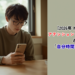 A young person sitting calmly by a sunlit window, gently placing a smartphone face-down on a wooden table, holding a warm cup of tea, soft natural morning light, minimalist Japanese interior, muted sage green and warm beige palette, soft focus background, sense of relief and breathing space, lifestyle editorial photography, clean modern composition, negative space on the right for text overlay --ar 1200:630